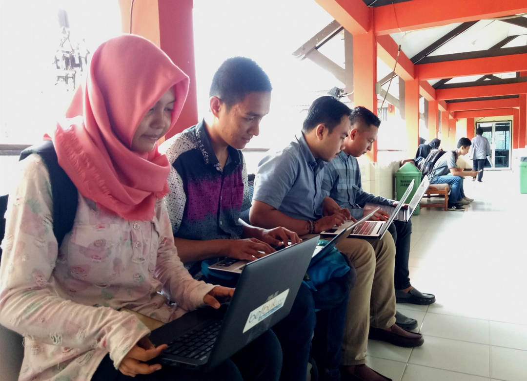 Sekumpulan Mahasiswa yang Sedang Membuka Laptop di Area Lorong Kampus (Sumber: Dokumen Penulis)